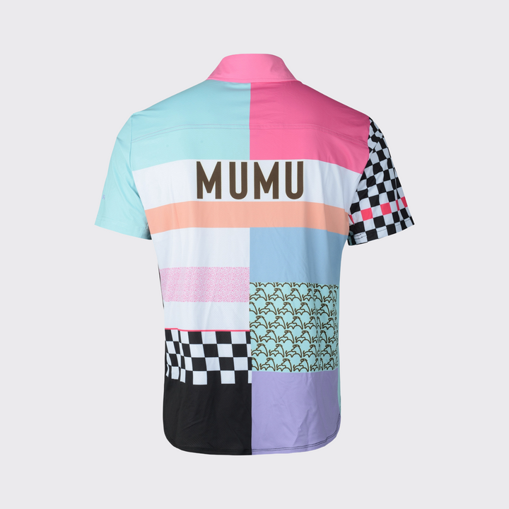 Back view of a short-sleeve MUMU button-down shirt with a colorful patchwork design in pink, teal, blue, peach, lavender, and black-and-white checkerboard panels, featuring large MUMU lettering across the upper back.
